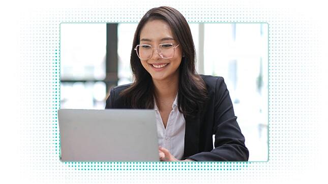 Woman smiling, looking at laptop