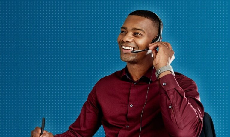 Man smiling, using headset at desk