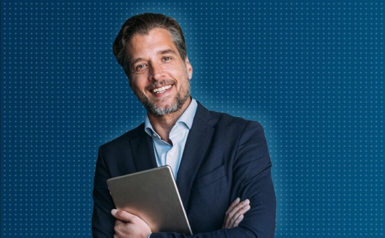 Man in suit smiling, holding tablet