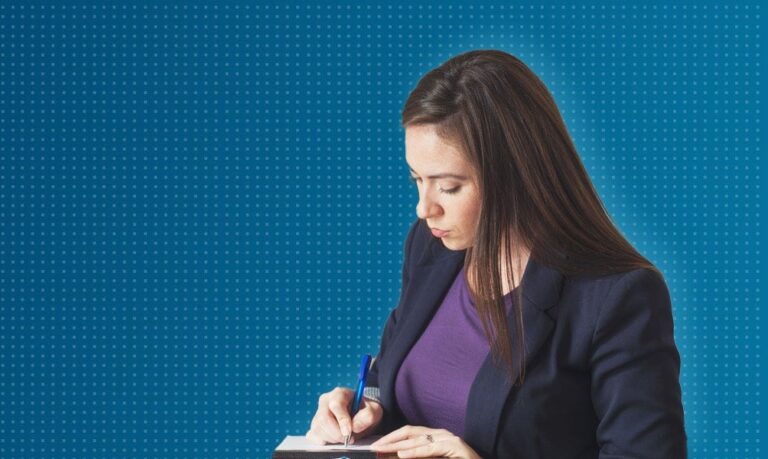 Woman writing in notebook at desk